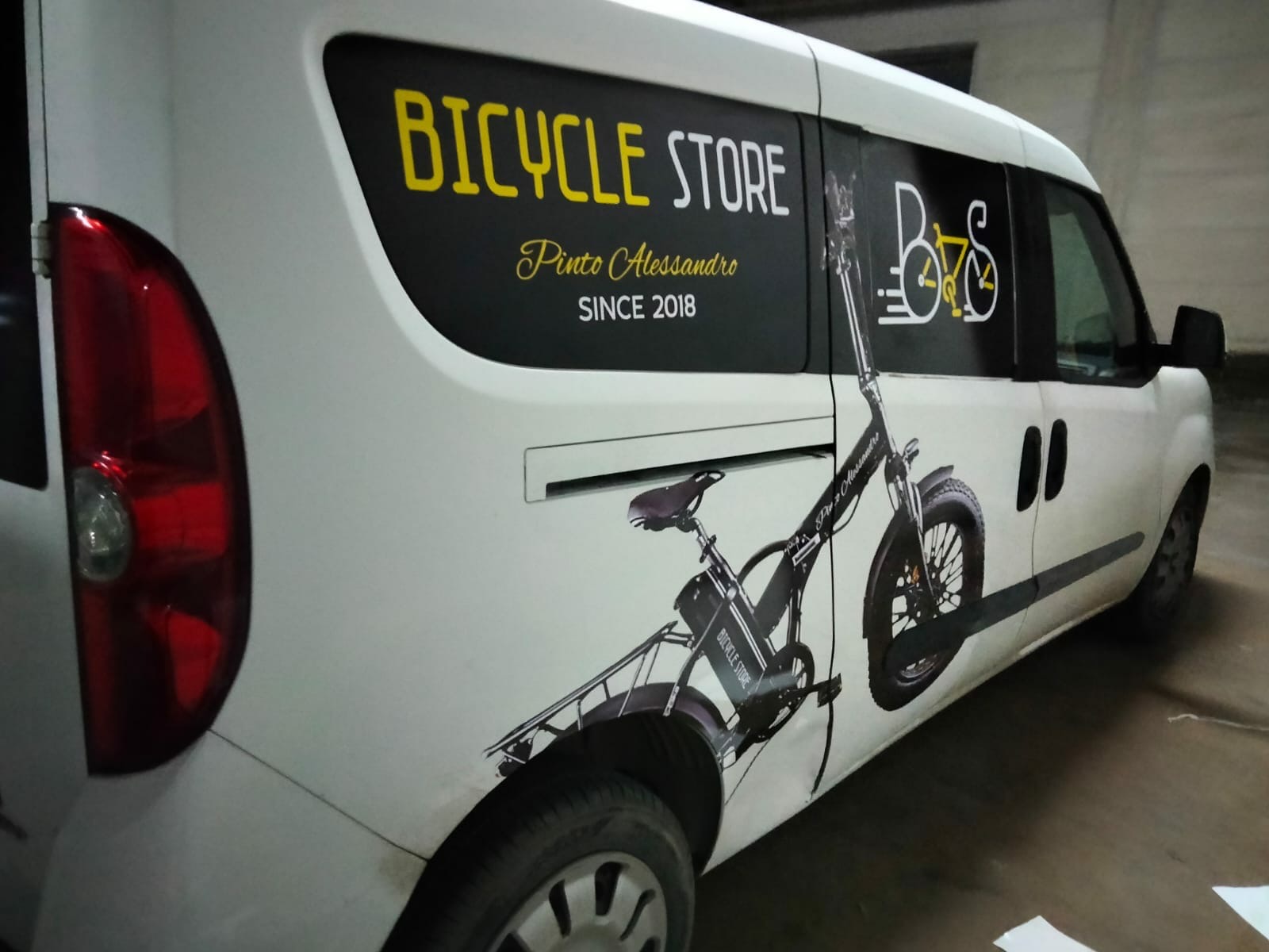 Furgone bianco con grafica stampata di un negozio di biciclette