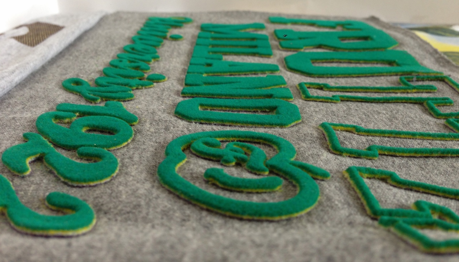 Grandi lettere in flock verde su tessuto