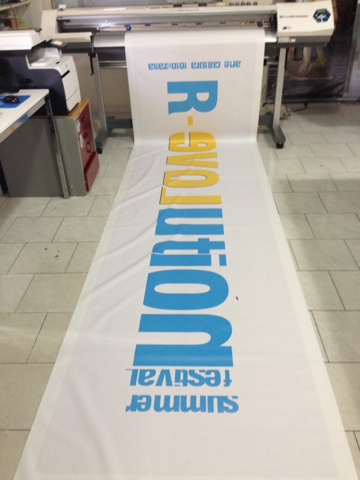 Banner di grande formato appena stampato e steso nel laboratorio