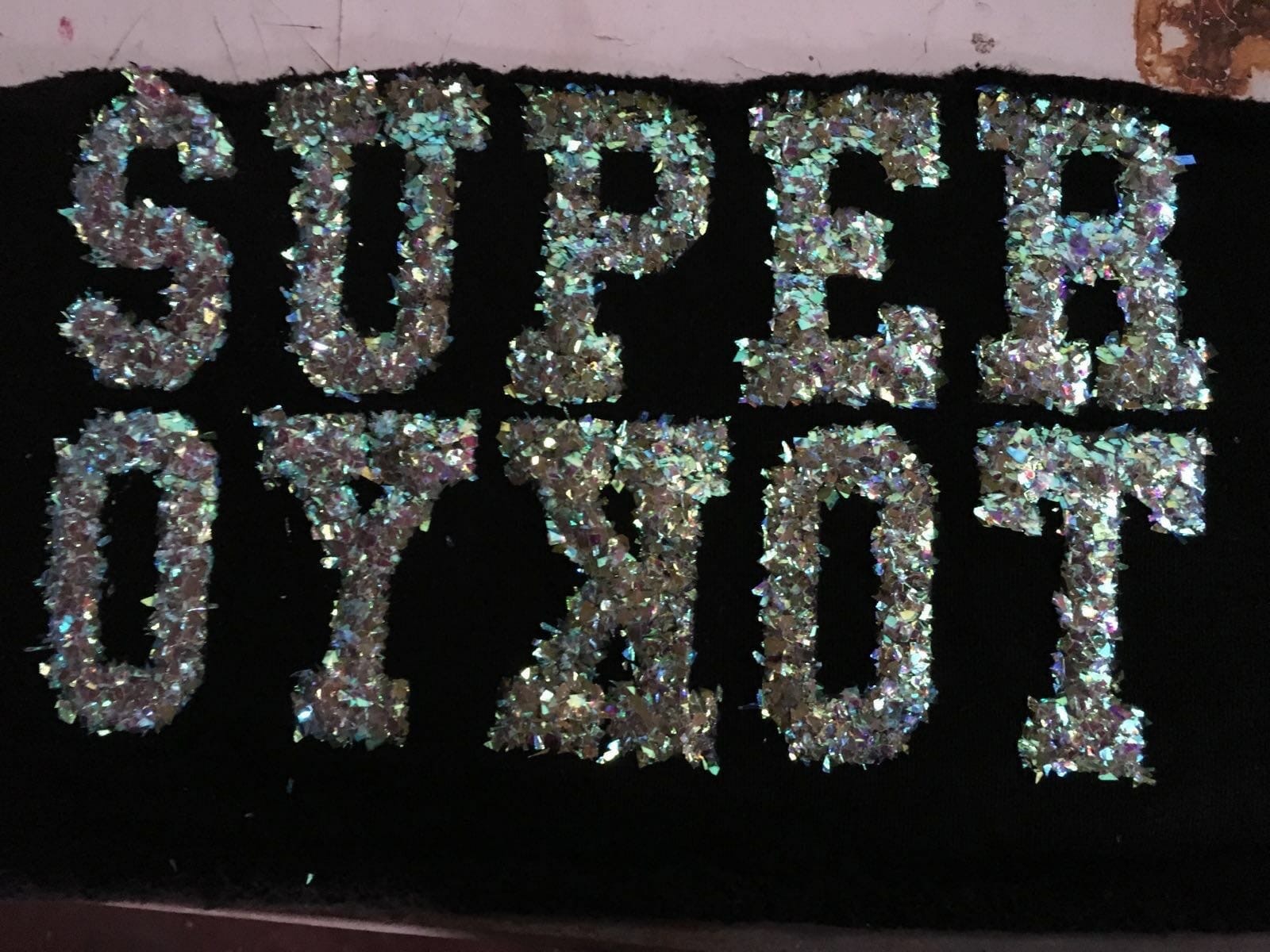 Scritta Super Tokyo con effetto payett brillante